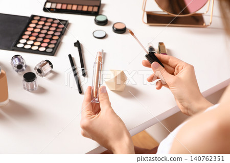 Beauty blogger with liquid eyeshadow at table, closeup Beauty blogger with liquid eyeshadow at table, closeup 140762351