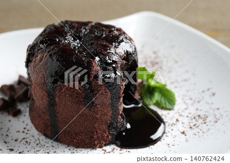Delicious warm chocolate lava cake on plate, closeup Delicious warm chocolate lava cake on plate, closeup 140762424