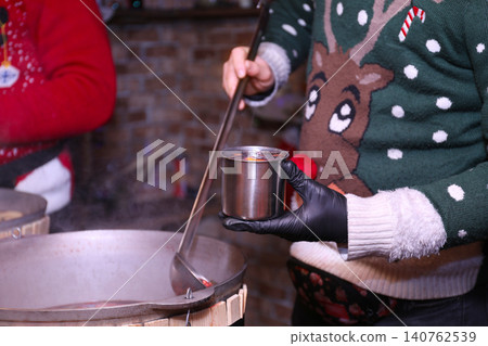 Seller with tasty mulled wine at winter fair, closeup 140762539