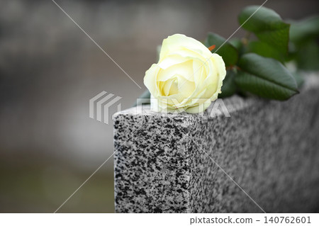 White rose on grey granite tombstone outdoors. Funeral ceremony White rose on grey granite tombstone outdoors. Funeral ceremony 140762601