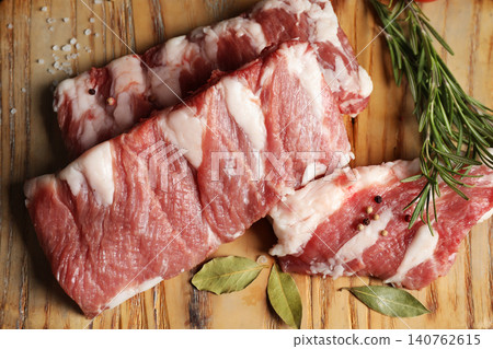 Raw ribs with herbs and spices on wooden table, flat lay Raw ribs with herbs and spices on wooden table, flat lay 140762615