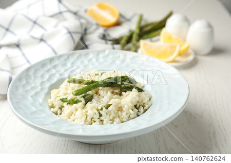 Delicious risotto with asparagus on white wooden table Delicious risotto with asparagus on white wooden table 140762624