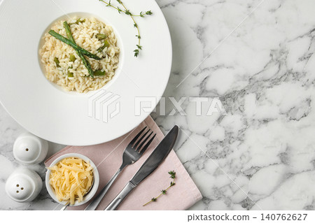 Delicious risotto with asparagus served on marble table, flat lay Delicious risotto with asparagus served on marble table, flat lay 140762627