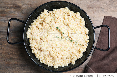 Delicious risotto with cheese on wooden table, top view Delicious risotto with cheese on wooden table, top view 140762629