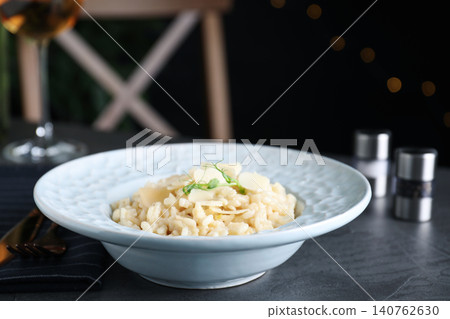 Delicious risotto with cheese on grey table Delicious risotto with cheese on grey table 140762630