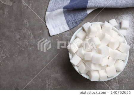 Refined sugar cubes in bowl on grey table, flat lay. Space for text Refined sugar cubes in bowl on grey table, flat lay. Space for text 140762635