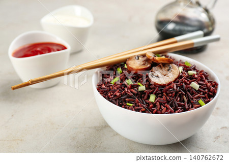 Tasty brown rice with mushrooms on light grey table Tasty brown rice with mushrooms on light grey table 140762672