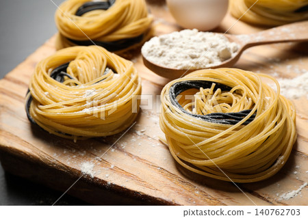 Raw linguine pasta on wooden board, closeup Raw linguine pasta on wooden board, closeup 140762703