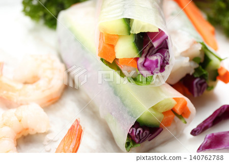 Delicious rolls wrapped in rice paper on table, closeup 140762788