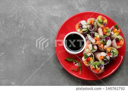 Delicious rolls wrapped in rice paper served on grey table, top view. Space for text Delicious rolls wrapped in rice paper served on grey table, top view. Space for text 140762792