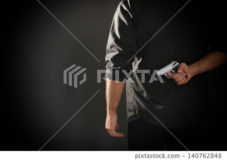 Professional killer with gun on black background, closeup. Space for text 140762848
