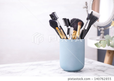 Set of professional makeup brushes in holder on white marble table. Space for text Set of professional makeup brushes in holder on white marble table. Space for text 140762855