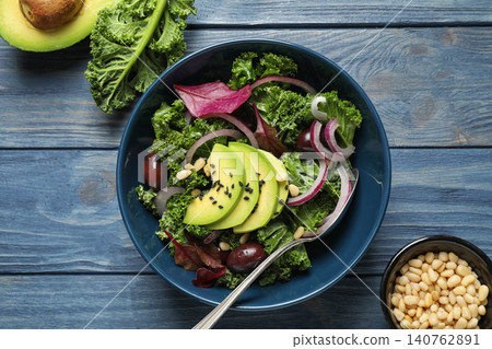 Tasty fresh kale salad on blue wooden table, flat lay 140762891
