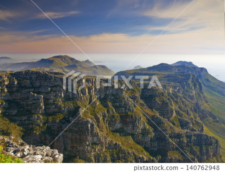 Mountain, nature and sky with green cliff, clouds and natural landscape for travel location. Hill, fog and sustainable environment with ocean, peace and holiday destination with drone view of earth 140762948
