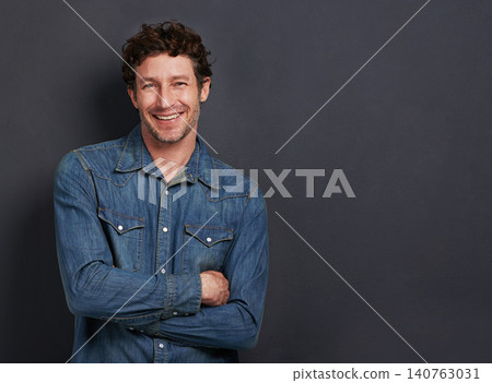 Studio, portrait and man with confidence, casual fashion and mockup space for creative professional. Relax, happy and face of person with smile, pride and trendy denim style on dark grey background Studio, portrait and man with confidence, casual fashion and mockup space for creative professional. Relax, happy and face of person with smile, pride and trendy denim style on dark grey background 140763031