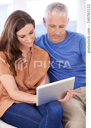 Couple, tablet and relax on couch in home with reading, search and app to watch movie with bonding. People, woman and mature man on digital touchscreen for notification with web connection in house 140763112