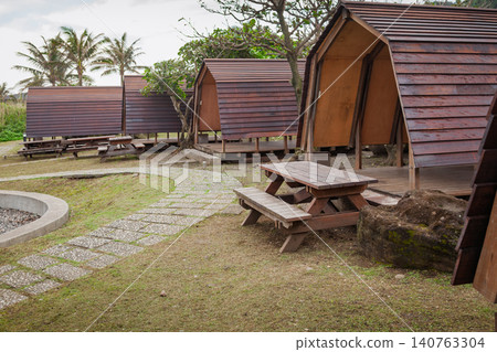 Wooden camping shelters beside a seaside path Wooden camping shelters beside a seaside path 140763304