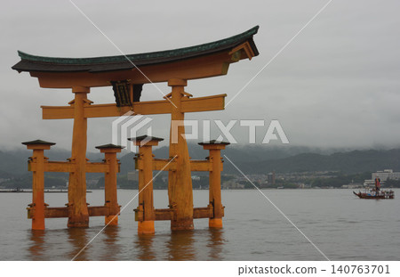 Itsukushima shrine red gate next to a boat for the Kangen-sai. Itsukushima shrine red gate next to a boat for the Kangen-sai. 140763701