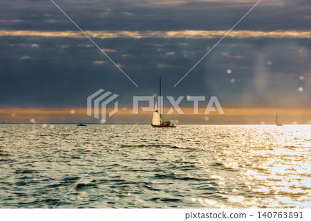 Vintage sailing boat through splashing water at sunset, Sailing regatta in the Gulf of Finland at sunset, hot race of several yachts, teamwork 140763891