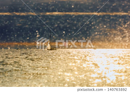 Vintage sailing boat through splashing water at sunset, Sailing regatta in the Gulf of Finland at sunset, hot race of several yachts, teamwork Vintage sailing boat through splashing water at sunset, Sailing regatta in the Gulf of Finland at sunset, hot race of several yachts, teamwork 140763892