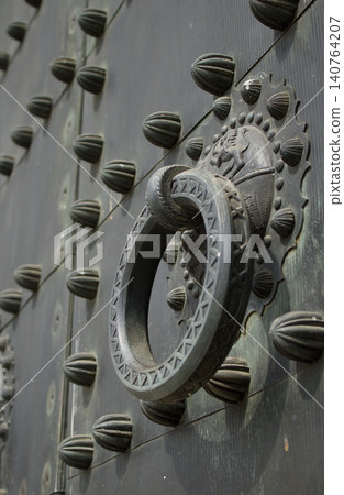 Detail of iron forge in the knocker of a big metallic door Detail of iron forge in the knocker of a big metallic door 140764207