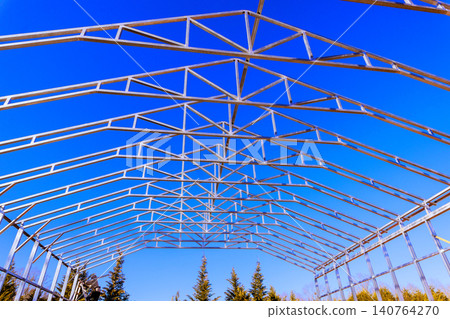 Workers are setting up metal frame for greenhouse surrounded by framework assembly process Workers are setting up metal frame for greenhouse surrounded by framework assembly process 140764270