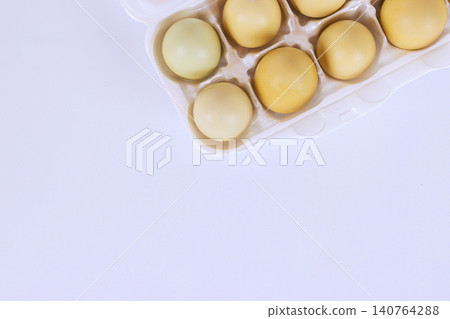 Carton holds farm eggs with varied colors on white surface, Carton holds farm eggs with varied colors on white surface, 140764288