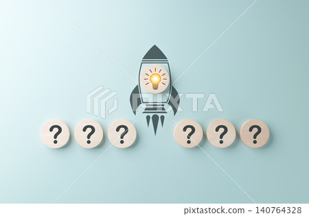 Creative startup concept. Wooden blocks with question marks and a rocket icon featuring a glowing light bulb at the center symbolize innovation, creative ideas, and launching new startup projects. Creative startup concept. Wooden blocks with question marks and a rocket icon featuring a glowing light bulb at the center symbolize innovation, creative ideas, and launching new startup projects. 140764328