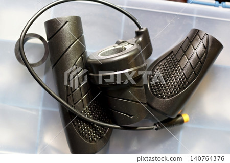 New black rubber grips and throttle assembly for an electric bike, featuring ergonomic textured design and wired connector, perfect for custom e-bike upgrade and repair projects 140764376
