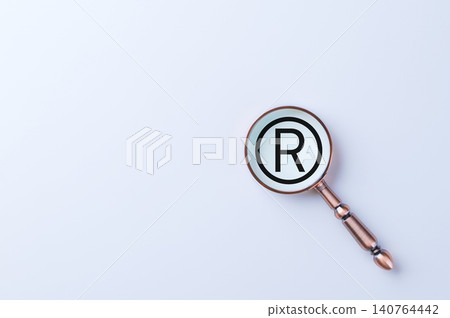 Registered Trademark Symbol. A magnifying glass focusing on registered trademark symbol (R in a circle) on white background, representing legal brand protection, branding, and intellectual property. Registered Trademark Symbol. A magnifying glass focusing on registered trademark symbol (R in a circle) on white background, representing legal brand protection, branding, and intellectual property. 140764442