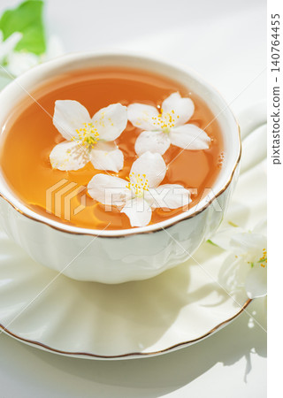 Jasmine tea in white cup with floating flowers Jasmine tea in white cup with floating flowers 140764455