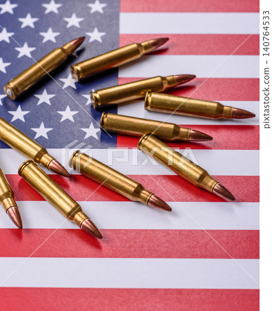 Assault rifle cartridges on the US flag, serving as a conceptual backdrop for defense Assault rifle cartridges on the US flag, serving as a conceptual backdrop for defense 140764533