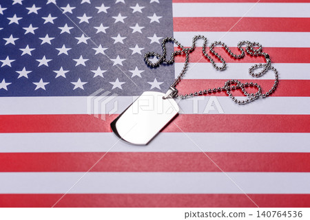 A dog tag on the US flag, serving as a conceptual backdrop representing defense A dog tag on the US flag, serving as a conceptual backdrop representing defense 140764536