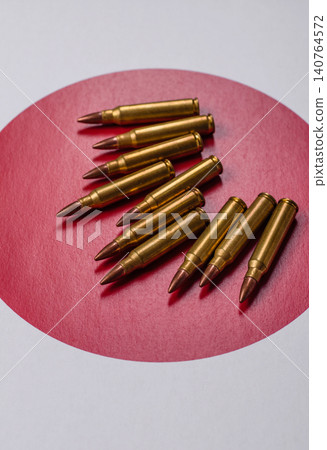 Assault rifle cartridges on the Japanese flag, serving as a conceptual backdrop for defense Assault rifle cartridges on the Japanese flag, serving as a conceptual backdrop for defense 140764572