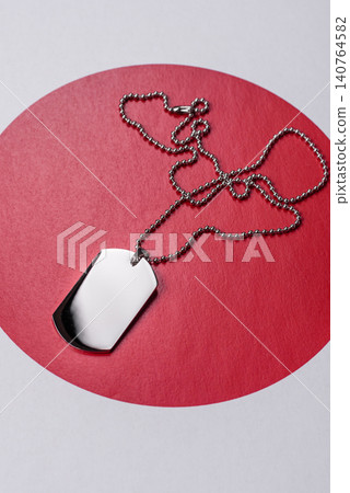 A dog tag on the Japanese flag, serving as a conceptual backdrop representing defense A dog tag on the Japanese flag, serving as a conceptual backdrop representing defense 140764582