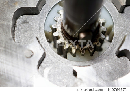 Close-up view of an electric bicycle motor planetary gear assembly featuring a metallic sun gear engaged with white nylon satellite gears on a maintenance bench 140764771