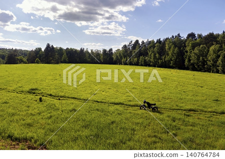Black fat bike stands alone in a vast vibrant green meadow under a sunny blue sky, capturing the essence of freedom and outdoor adventure in a peaceful rural landscape Black fat bike stands alone in a vast vibrant green meadow under a sunny blue sky, capturing the essence of freedom and outdoor adventure in a peaceful rural landscape 140764784