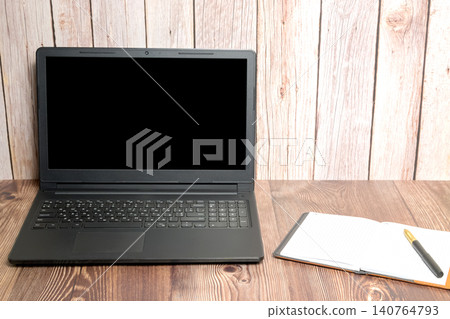open laptop and notebook with pen on table 140764793