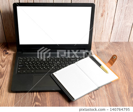 laptop with white screen and notebook on table laptop with white screen and notebook on table 140764795