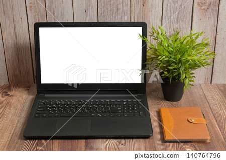 laptop with white screen notebook and plant on wooden table laptop with white screen notebook and plant on wooden table 140764796