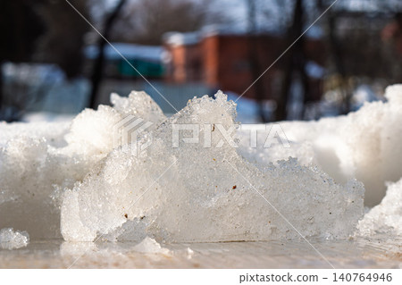 Close-up of glistening melting ice chunk on a bright spring day, bokeh background of muted colors and soft shapes Close-up of glistening melting ice chunk on a bright spring day, bokeh background of muted colors and soft shapes 140764946