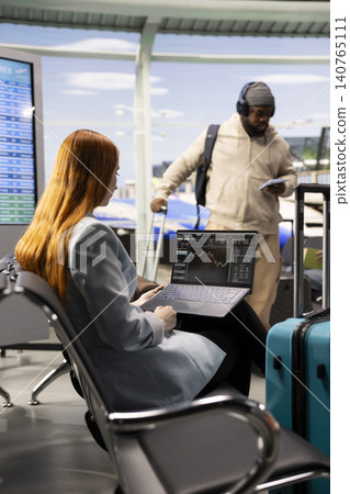 Professional woman reviewing stock charts and financial market insights in airport before departure, using online tools to track algorithms and hedge fund performance. Digital nomad freedom, Professional woman reviewing stock charts and financial market insights in airport before departure, using online tools to track algorithms and hedge fund performance. Digital nomad freedom, 140765111