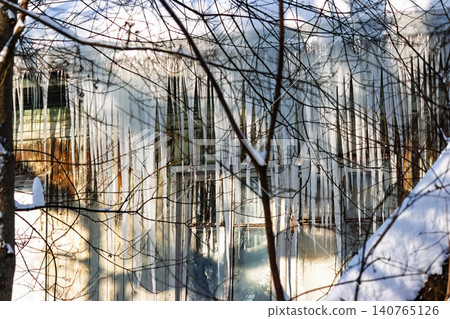 A perilous curtain of sharp icicles adorns the distressed facade of a ramshackle wooden home, capturing winter's icy grip and overlooked decay A perilous curtain of sharp icicles adorns the distressed facade of a ramshackle wooden home, capturing winter's icy grip and overlooked decay 140765126