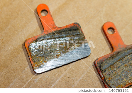 Worn out bicycle brake pads showing metal backing, indicating total wear and need for immediate replacement Worn out bicycle brake pads showing metal backing, indicating total wear and need for immediate replacement 140765161