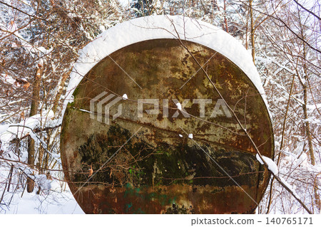 Weathered old water tank, partially covered in fresh snow, nestled in a peaceful winter forest. Rustic charm of a dacha settlement utility Weathered old water tank, partially covered in fresh snow, nestled in a peaceful winter forest. Rustic charm of a dacha settlement utility 140765171