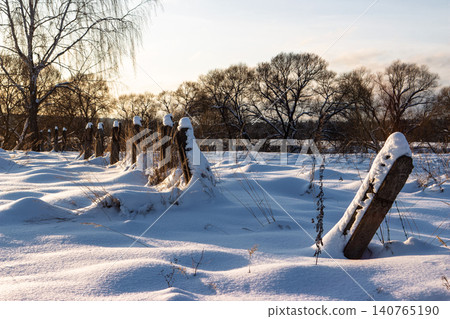 A stark winter scene with decaying fence posts buried in deep snow drifts, evoking themes of former Soviet labor camps and northern isolation A stark winter scene with decaying fence posts buried in deep snow drifts, evoking themes of former Soviet labor camps and northern isolation 140765190