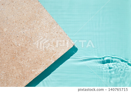 Travertine coping with turquoise swimming pool water surface Travertine coping with turquoise swimming pool water surface 140765715
