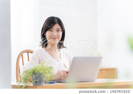 Woman working at home using a computer Woman working at home using a computer 140765920