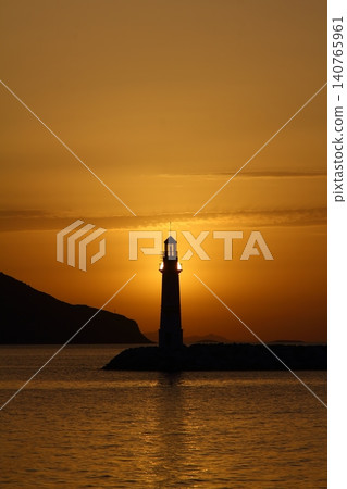 Seascape at sunshine. Lighthouse and sailings on the coast. Seaside town of Turgutreis and spectacular sunshine Seascape at sunshine. Lighthouse and sailings on the coast. Seaside town of Turgutreis and spectacular sunshine 140765961
