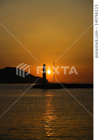 Seascape at sunshine. Lighthouse and sailings on the coast. Seaside town of Turgutreis and spectacular sunshine Seascape at sunshine. Lighthouse and sailings on the coast. Seaside town of Turgutreis and spectacular sunshine 140766113